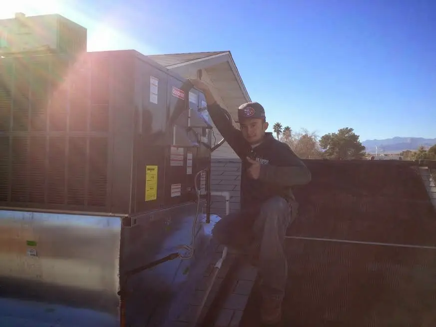 HVAC technician performing AC Tune-Up on a rooftop unit in Placentia